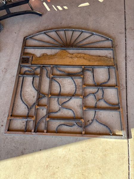 Arched gate panel in progress with a sunburst top and curved scroll bars