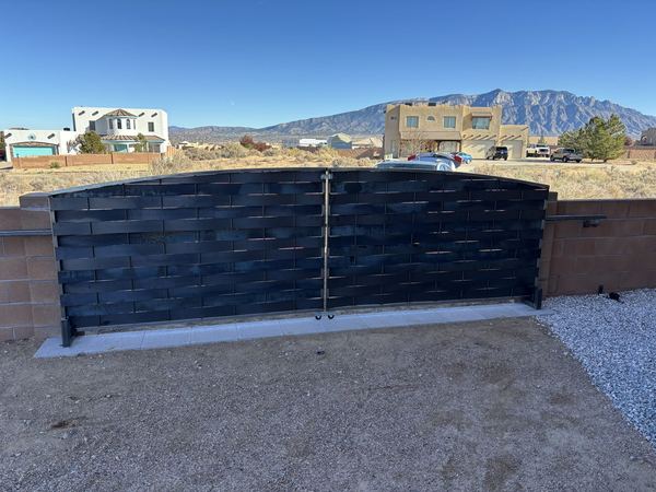Long woven steel gate in a block wall