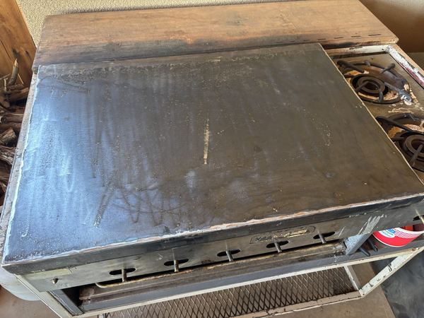 Flat steel griddle top fitted on a gas range
