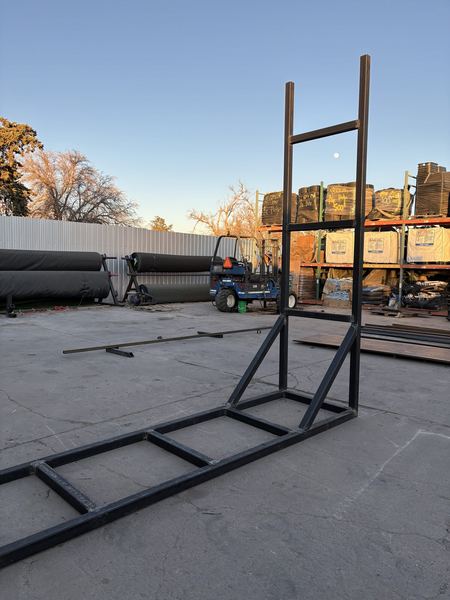 Welded square-tube steel frame standing in a yard