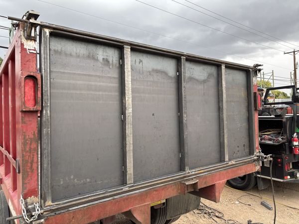 Red dump truck bed with new steel plate panels welded in